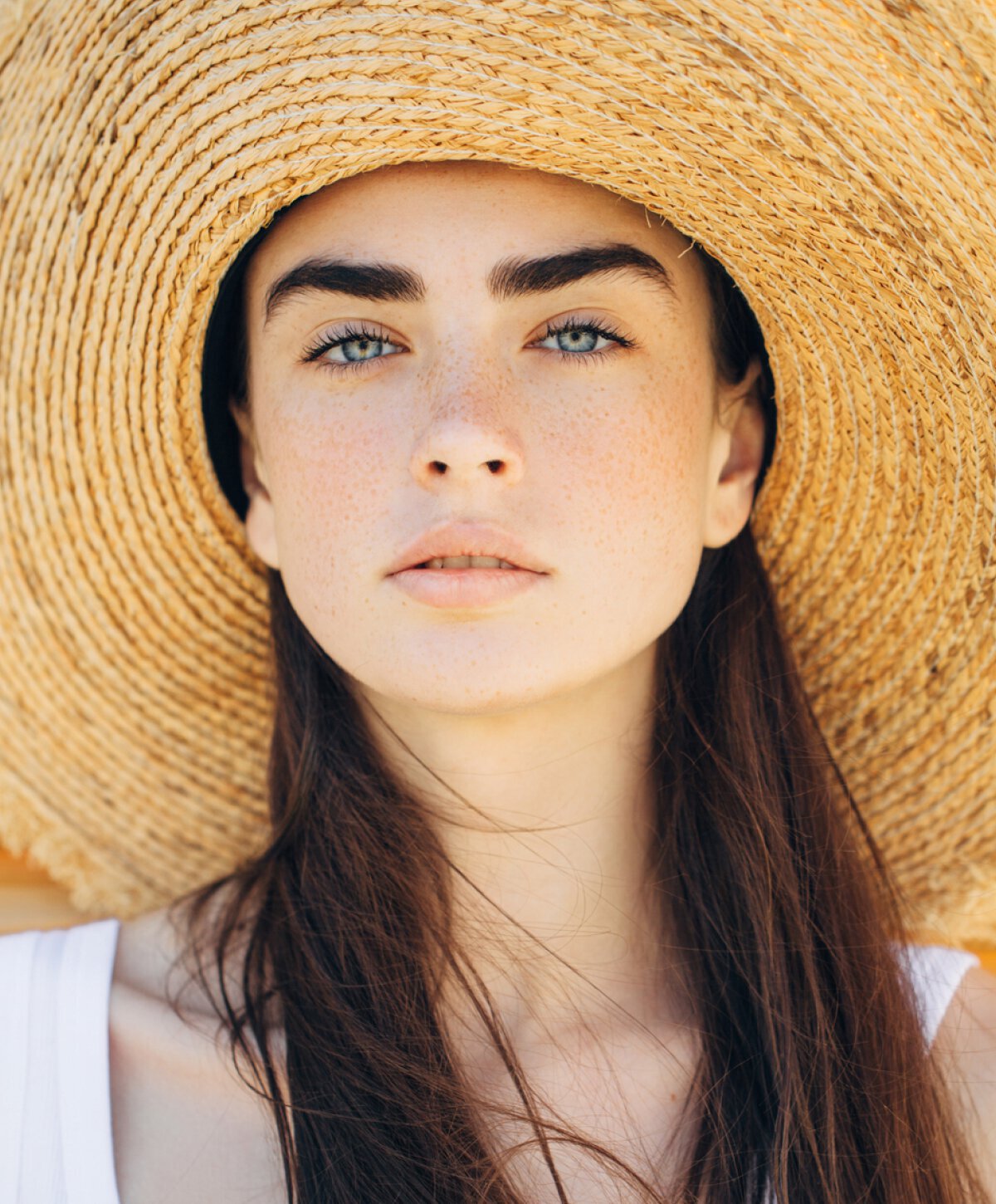 Woman with strong eyebrows and hat